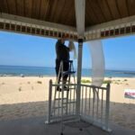 Hanging ceremony drapery at a beachside pavilion