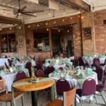 Wide view of the reception room with string lights and dining tables