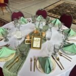Round reception table set with vintage china and a gold table number frame
